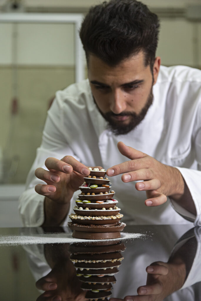 Pastry chef finishing a chocolate Christmas tree.
